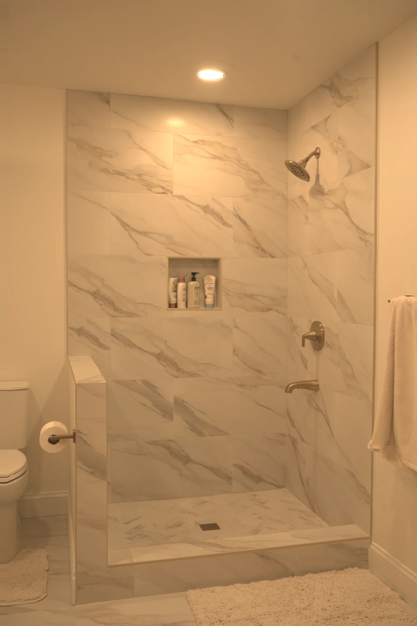 Basement bathroom marble-tile walk-in shower by Arch Basements