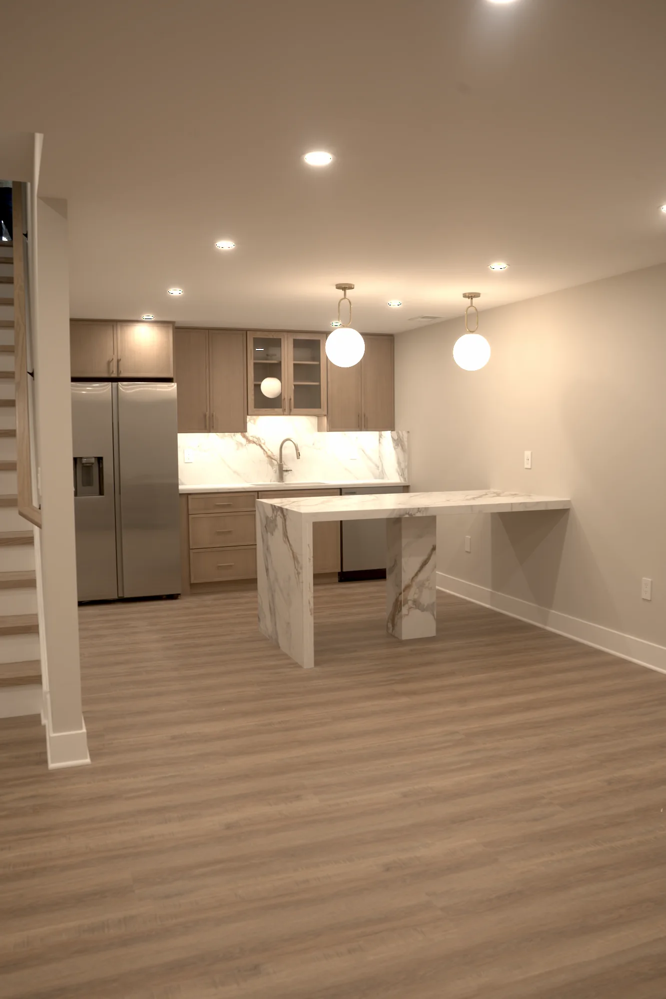 Custom basement wet bar and kitchenette with marble island